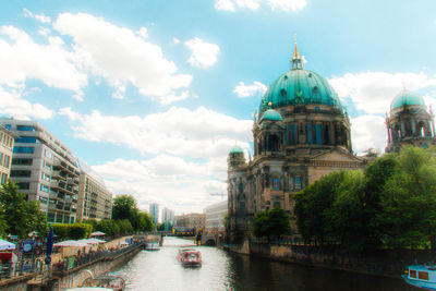 Buildings in city against cloudy sky