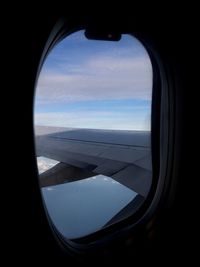 View of cloudy sky seen through airplane window