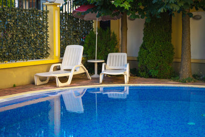 Chairs and table by swimming pool