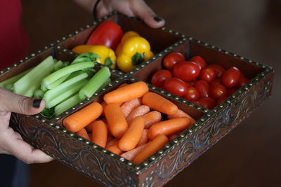 Cropped image of woman holding container with various vegetables