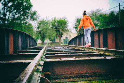 Rear view of man walking on railroad track