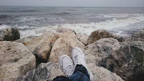 Low section of man on rock at beach