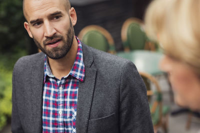 Mid adult businessman talking with female colleague at office yard