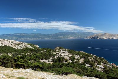 Scenic view of sea and mountains against blue sky