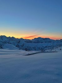Scenic view of snow covered mountains against sky during sunset