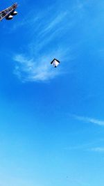 Low angle view of airplane flying against clear blue sky