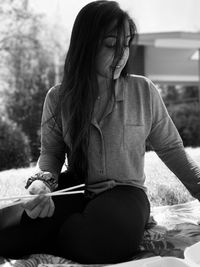 Side view of young woman sitting on chair