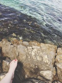 Low section of woman legs by sea