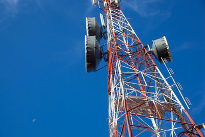 Low angle view of communications tower against clear blue sky