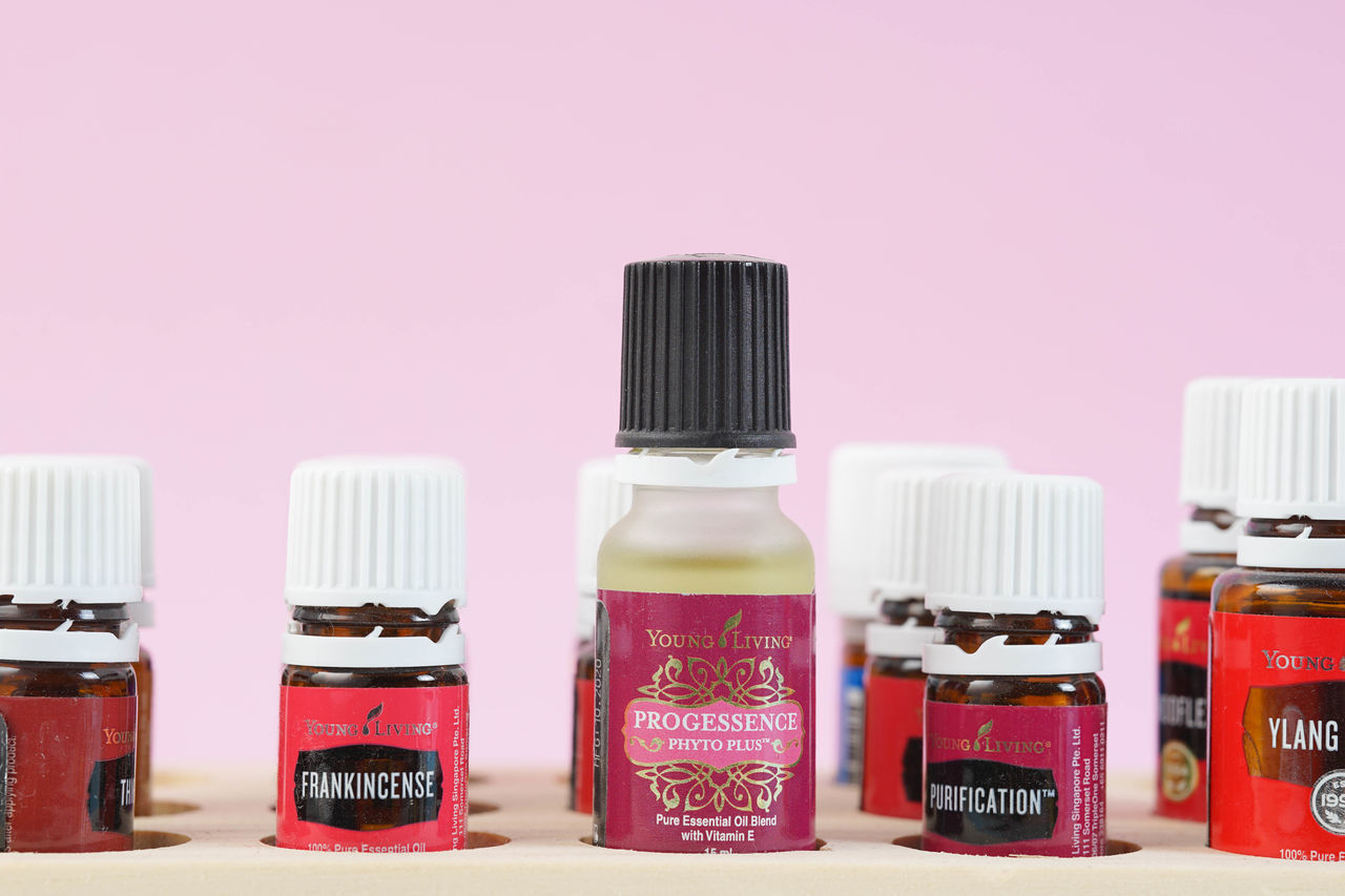 CLOSE-UP OF PINK BOTTLES ON SHELF AGAINST WHITE BACKGROUND