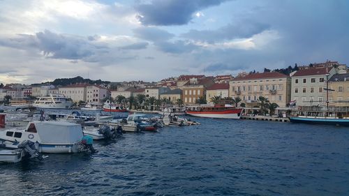 Boats in sea with buildings in background