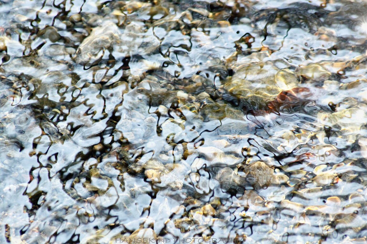 water, high angle view, stone - object, rock - object, nature, pebble, stone, full frame, tranquility, day, beauty in nature, outdoors, reflection, backgrounds, lake, no people, rock, rippled, pond, shallow