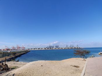 Scenic view of beach against blue sky