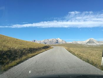 Country road against sky