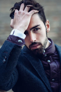 Portrait of young man with head in hands