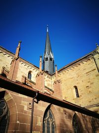 Low angle view of bell tower against blue sky