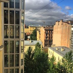 Buildings in city against cloudy sky