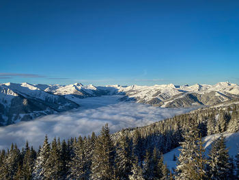 Scenic view of snowcapped mountains against blue sky