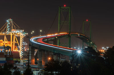 Illuminated bridge against sky at night