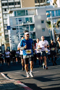 People running on street in city