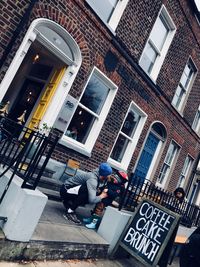 Low angle view of people sitting outside building