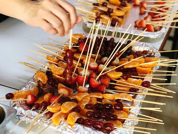 Close-up of person preparing food on barbecue grill