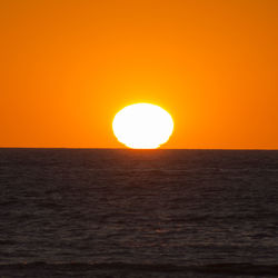 Scenic view of sea against orange sky
