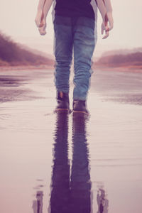 Low section of man standing on beach