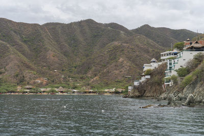 Scenic view of sea by buildings against sky