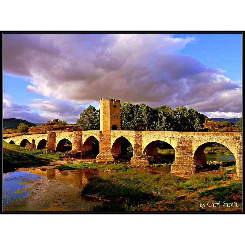 ARCH BRIDGE AND CLOUDY SKY OVER WATER