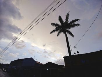 Low angle view of silhouette houses against sky