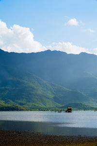 Scenic view of lake by mountains against sky
