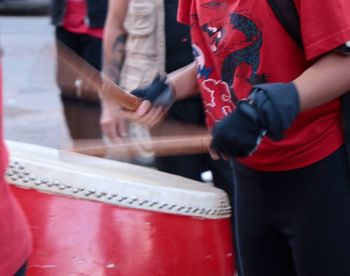 Midsection of man playing drum