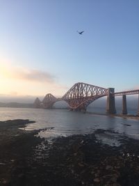 Firth of forth rail bridge over sea during sunset