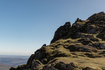 Low angle view of rock formation against clear blue sky