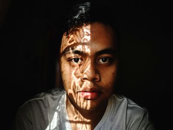 Close-up portrait of mid adult man in darkroom