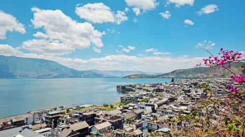 High angle view of townscape by sea against sky