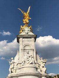 Low angle view of angel statue against cloudy sky