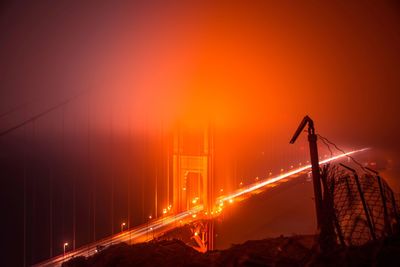 Illuminated bridge against sky during sunset