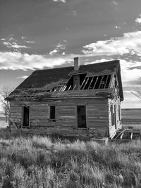 Abandoned barn on field against sky