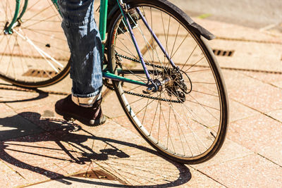 Low section of person riding bicycle during sunny day