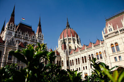 Low angle view of hungarian parliament building against clear blue sky