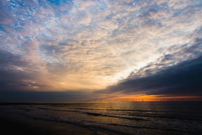 Scenic view of sea against dramatic sky during sunset