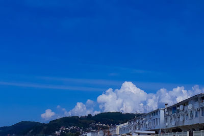 Low angle view of buildings in town against blue sky