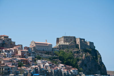 Buildings in town against clear blue sky