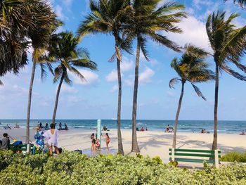 People enjoying at beach against sky