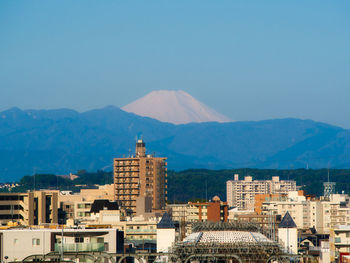 Buildings in city against blue sky