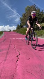 Man riding bicycle on pink road