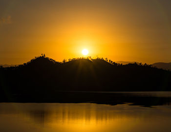 Scenic view of lake against orange sky