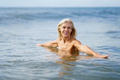 Portrait of young woman swimming in sea